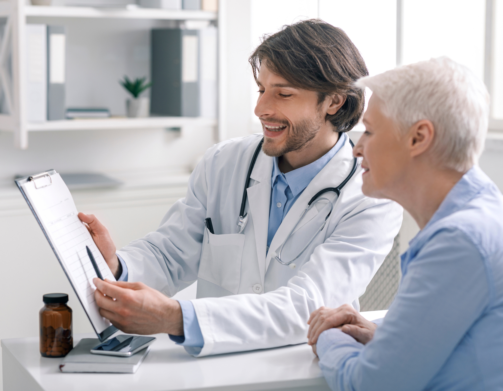 Senior Woman Talking To A Doctor Holding Medical File